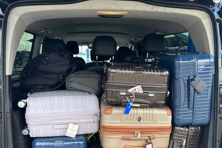 Spacious vehicle trunk loaded with various suitcases, ideal for convenient airport transfers in Rome.