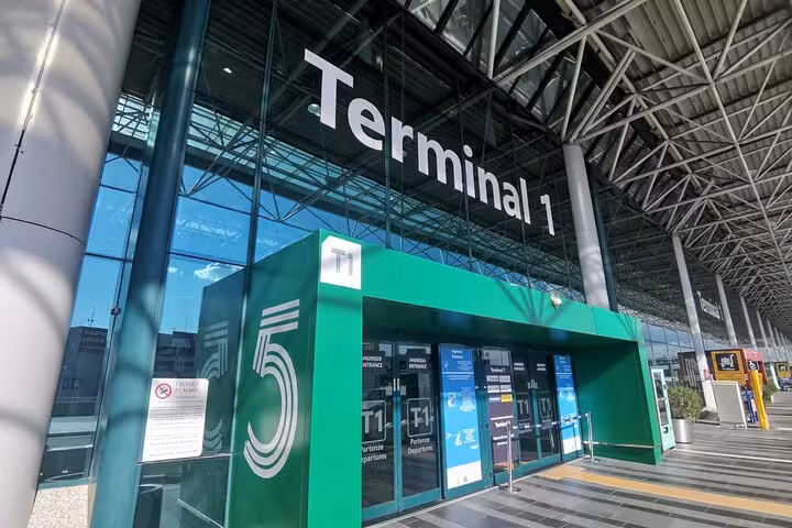 Exterior view of Terminal 1 at Fiumicino Airport, highlighting main entrance for airport transfers.