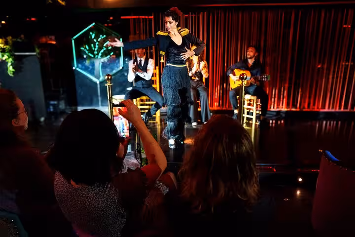 Captivating flamenco dancer performs live with musicians at an intimate Barcelona show, offering an authentic cultural experience.