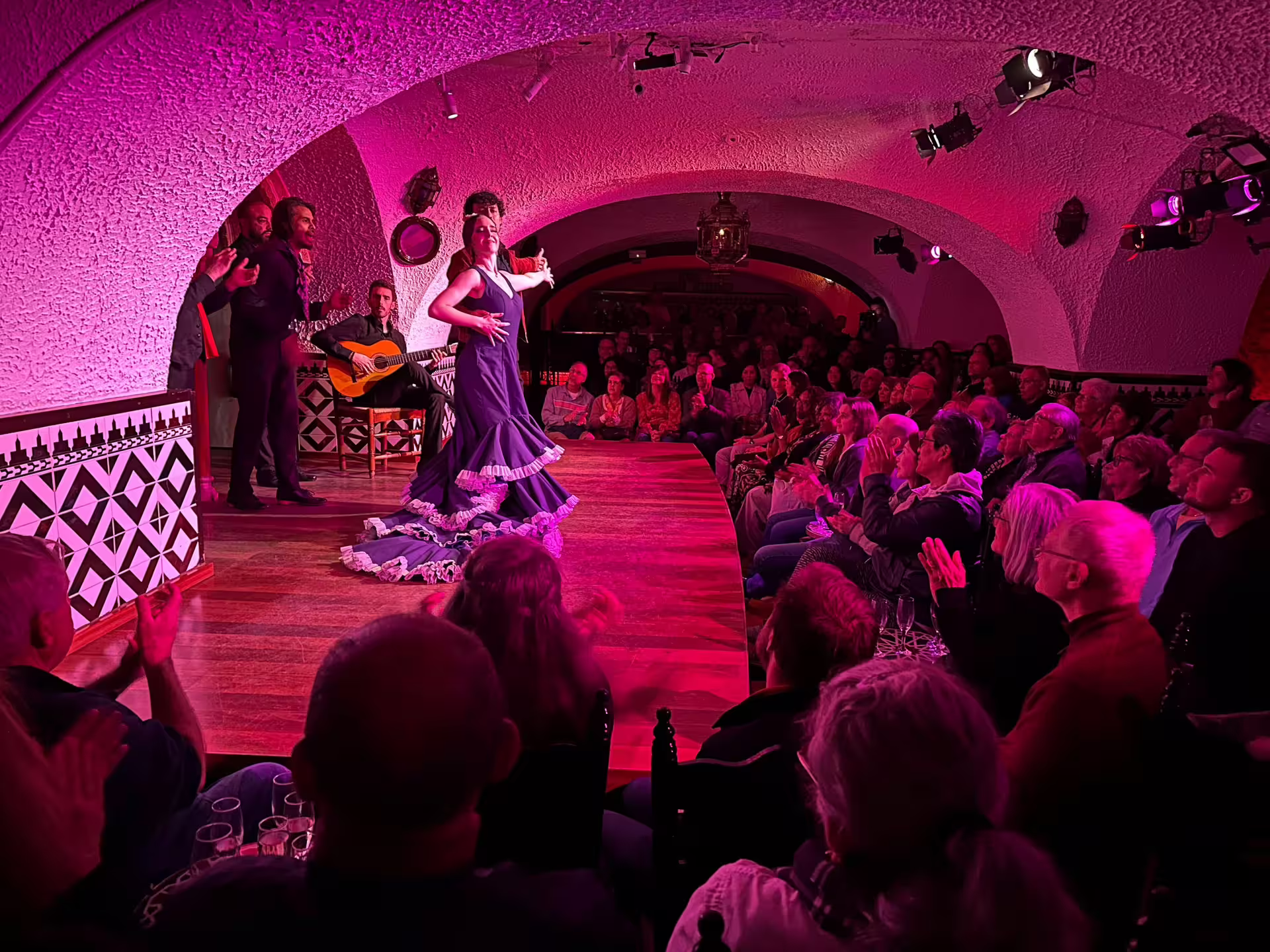 Vibrant Flamenco dancer performs at Tablao Cordobes in Barcelona, captivating a packed audience with traditional music.