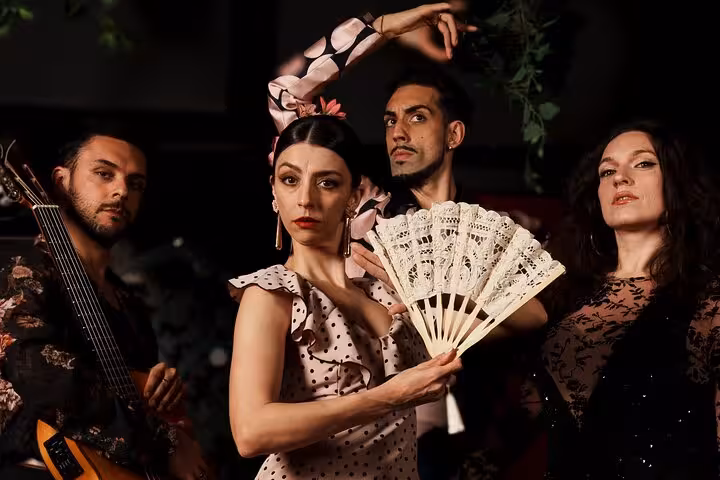 Passionate flamenco performers in traditional attire with fan, showcasing authentic dance in Barcelona's vibrant show.