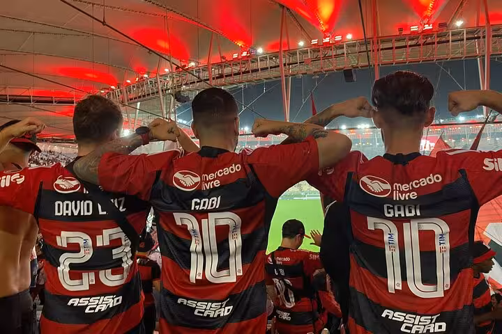 Flamengo fans in red-and-black jerseys cheering inside Maracanã Stadium during a live match in Rio de Janeiro