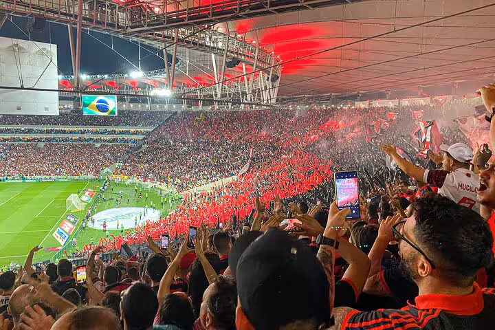 Flamengo fans celebrate at Maracanã Stadium in Rio with red flares during a live matchday experience