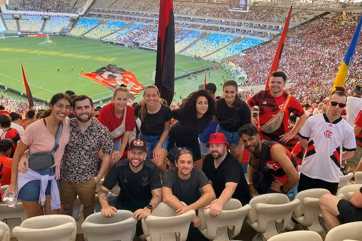 Tour group in Flamengo colors cheering at Maracanã Stadium, Rio de Janeiro, during a live matchday experience