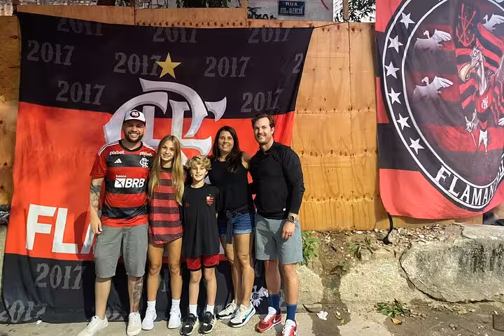 Tour guests pose by Flamengo banners outside Maracanã, pre-game photo stop on Rio de Janeiro matchday experience