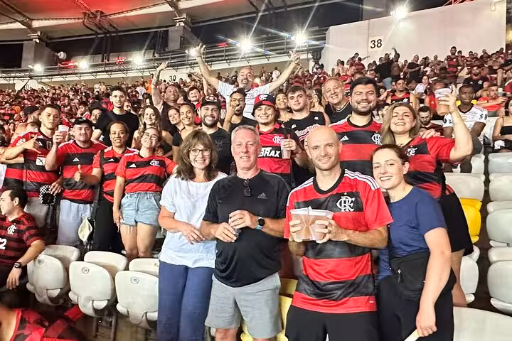 Happy Flamengo supporters in red-and-black jerseys in Maracanã Stadium stands during a Rio matchday tour