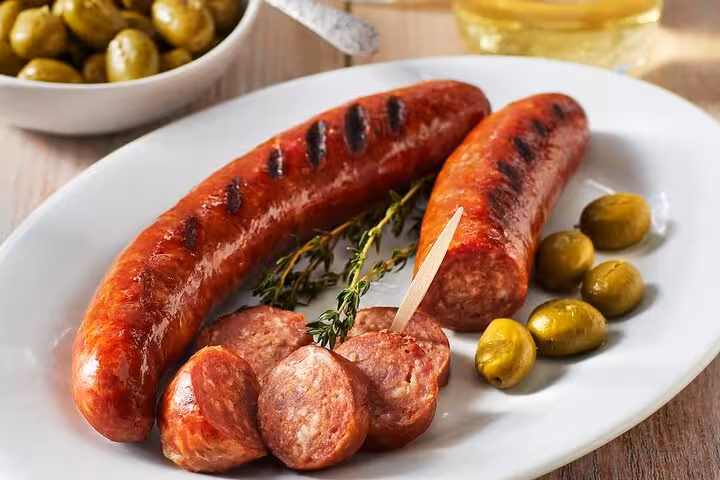 Savor flaming Portuguese sausage with olives on the Ultimate Lisbon Food Tour's street eat adventure.