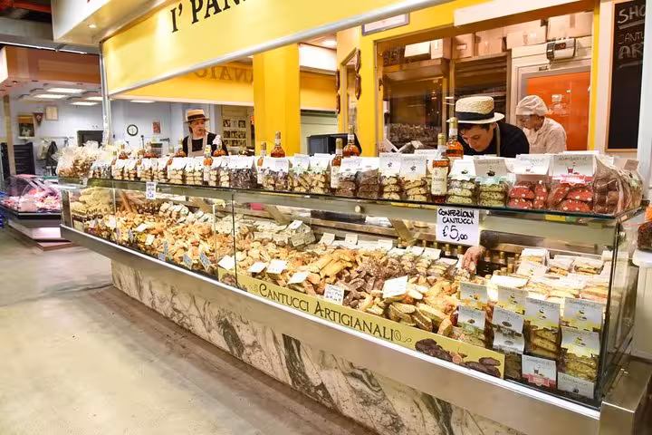 A vibrant market stall in Florence offers a variety of artisanal cantucci during a tasting excursion from Livorno.