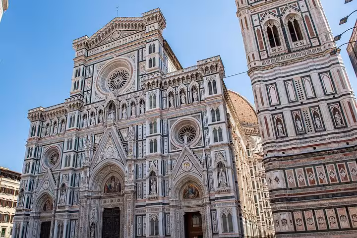 Stunning view of Florence Cathedral facade and Giotto's Bell Tower under a clear blue sky.