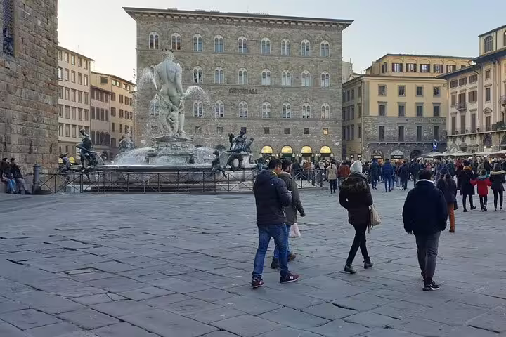 Tourists exploring Piazza della Signoria and Neptune Fountain in Florence on a private shore excursion from Livorno