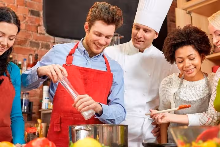 Group enjoying a hands-on cooking class in Florence with a chef, preparing fresh ingredients together.