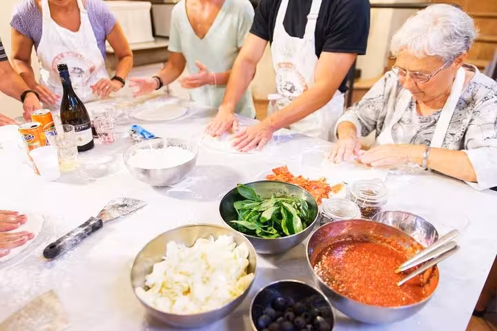 Group preparing Italian dishes with fresh ingredients during a hands-on cooking class in Florence.