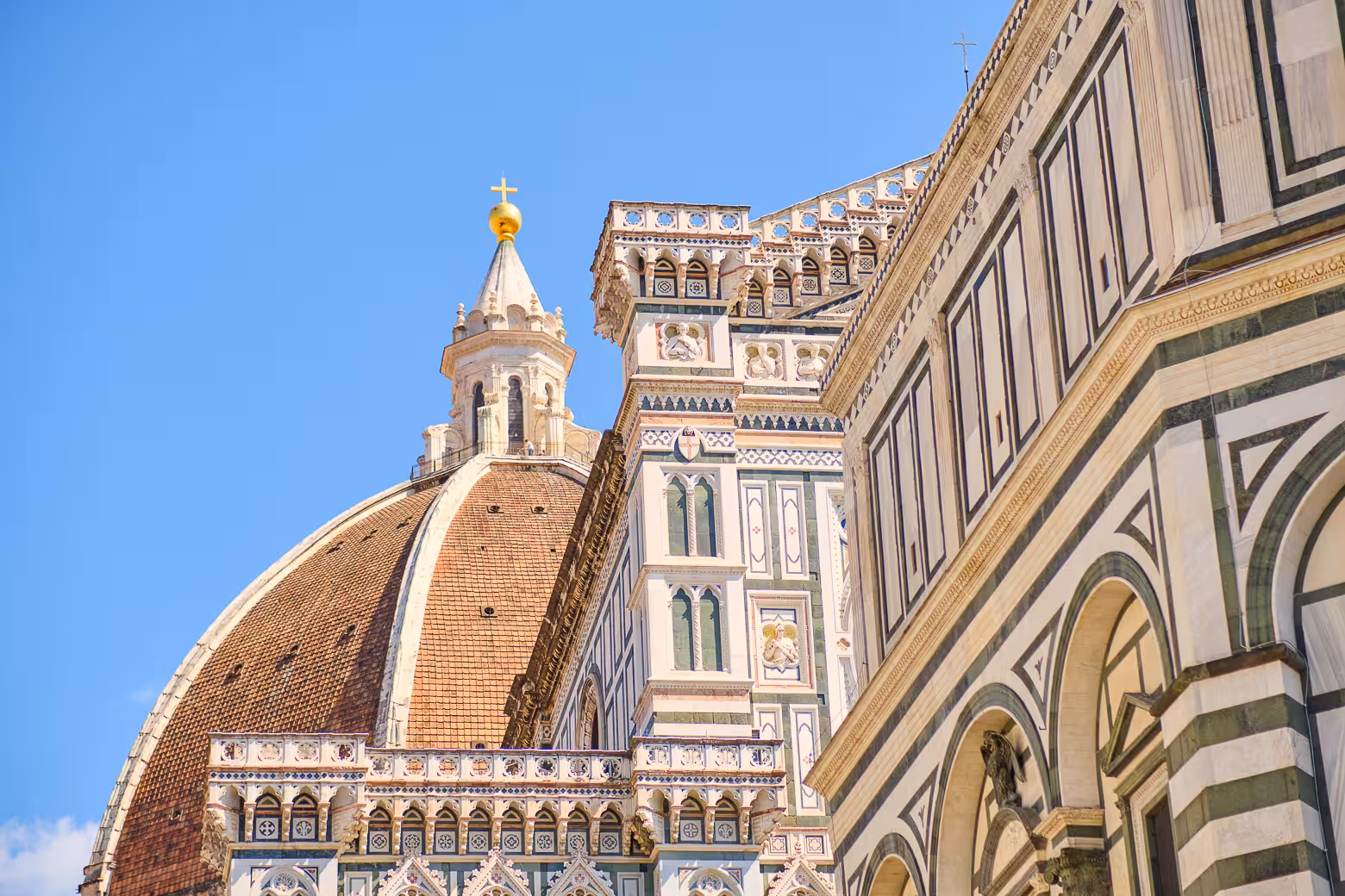 Close-up of Florence's iconic Duomo, showcasing its intricate architecture and stunning dome against a clear blue sky.