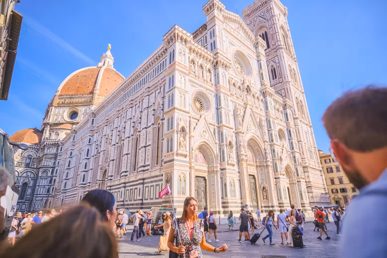 A guide leads a small group past the ornate facade of Florence Duomo Cathedral, highlighting its architectural grandeur.
