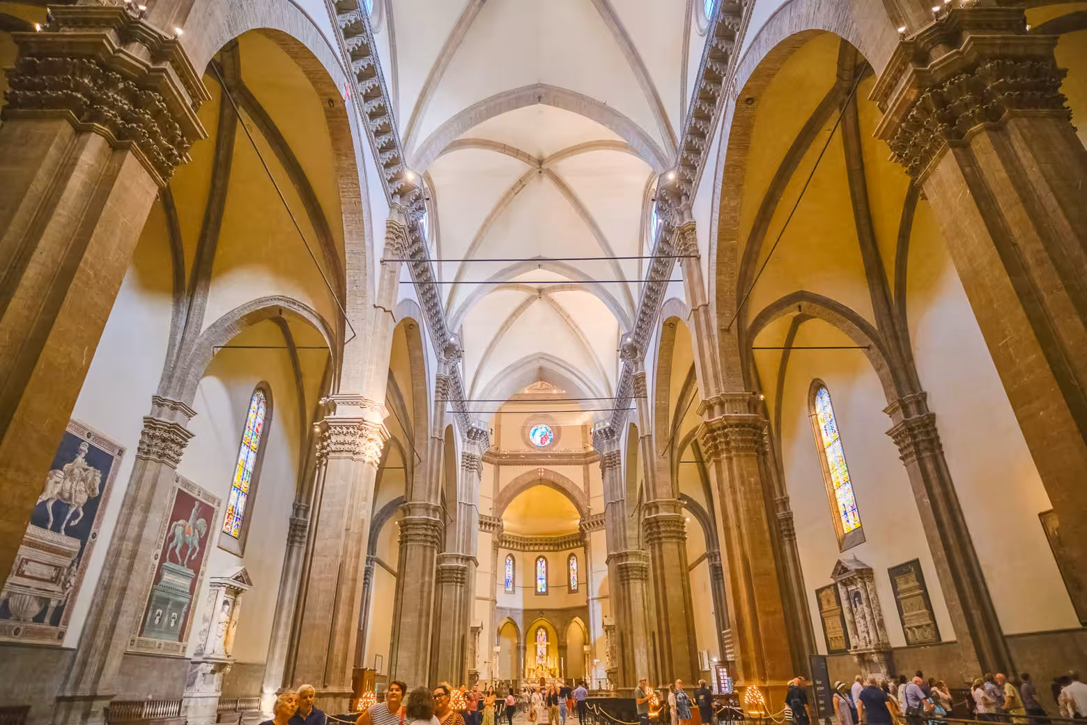Interior view of Florence's Duomo showcasing its grand arches and intricate stained glass, a highlight of Italian architecture.