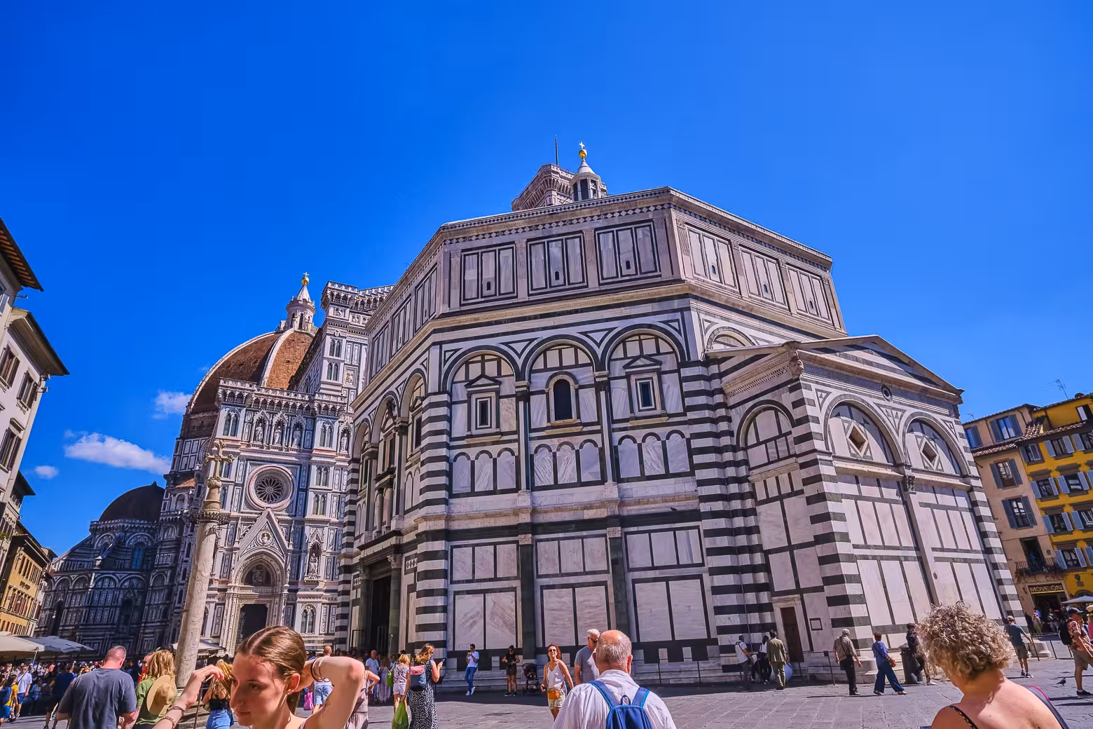 Tourists explore the Piazza del Duomo in Florence, highlighting the grandeur of the cathedral and Baptistery.