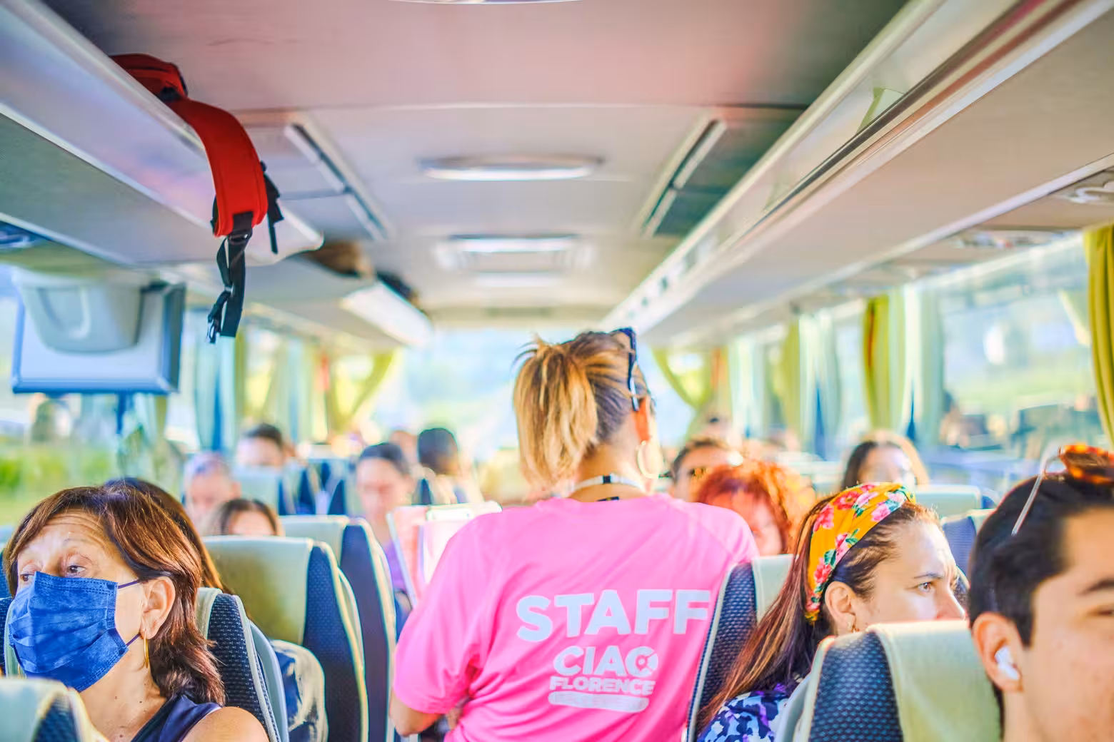 Tourists inside a comfortable tour bus traveling from Florence to Pisa and Cinque Terre with attentive staff.