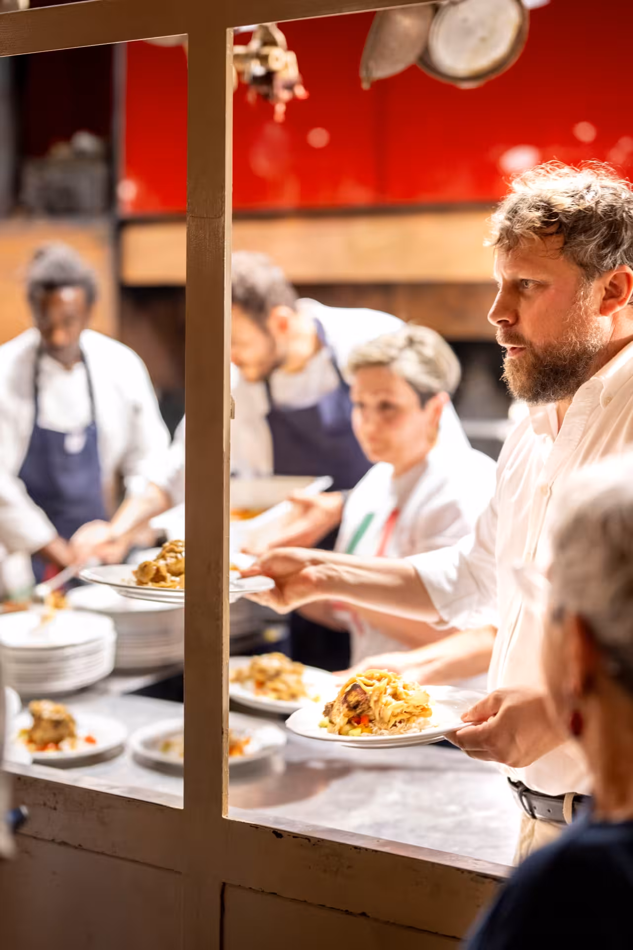 Florence Teatro del Sale dinner and show service, staff plating Tuscan dishes in lively open-kitchen setting