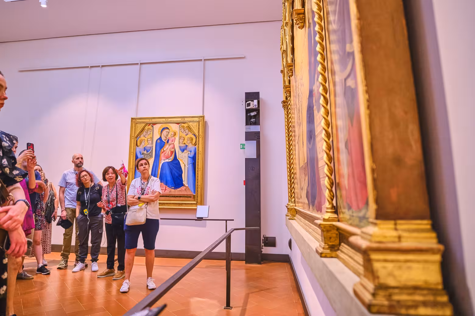 Visitors admire Renaissance artwork during a guided tour at Florence's Uffizi Gallery.