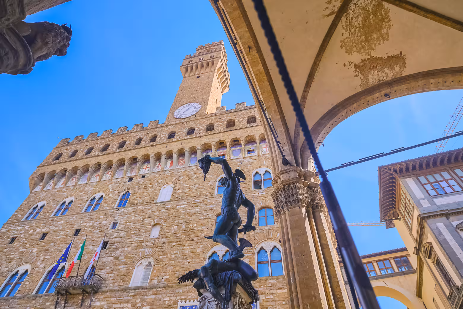 View of Palazzo Vecchio and Perseus statue in Florence on a sunny day during a small group walking tour.