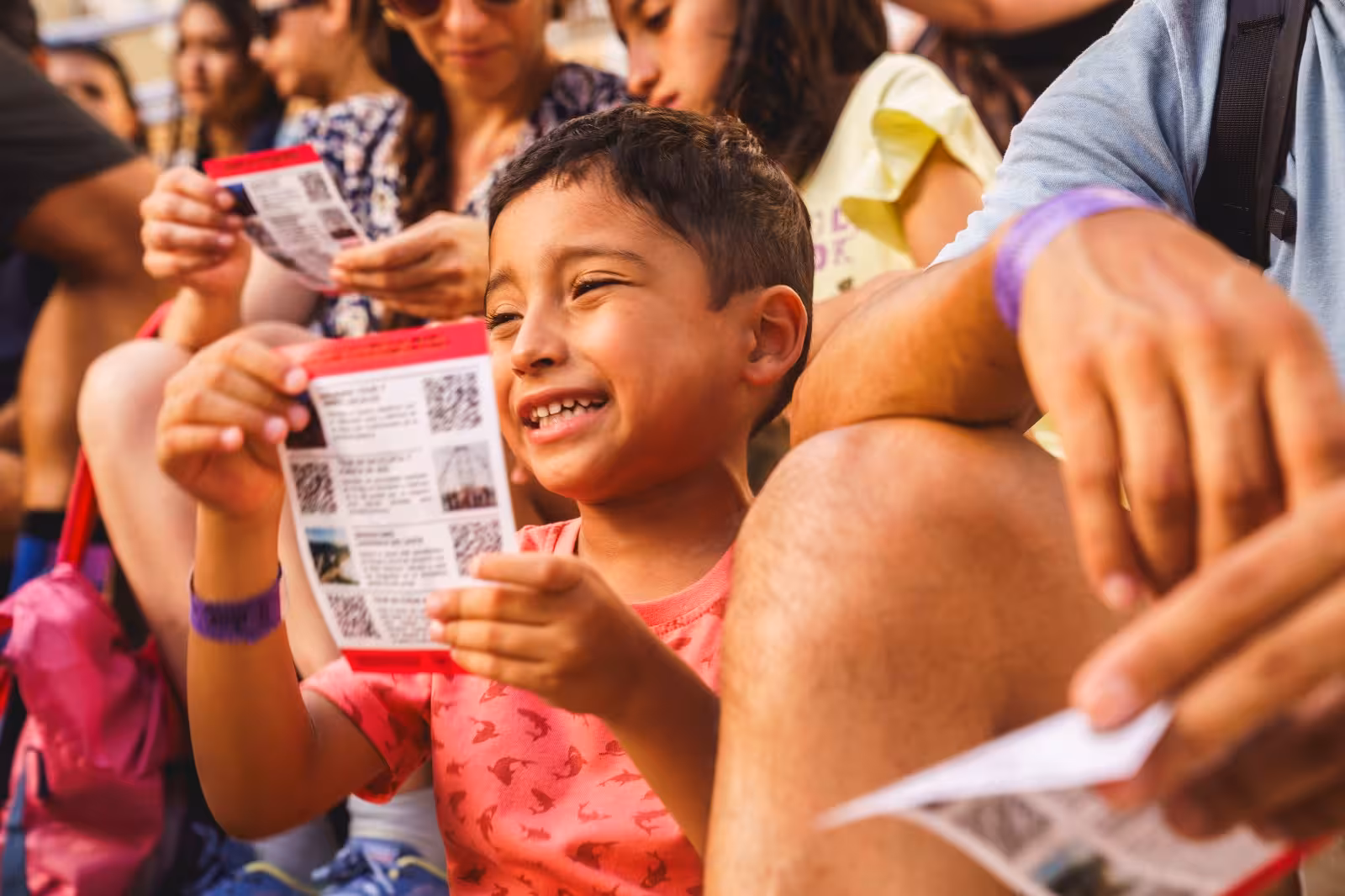 Smiling child holding a tour pamphlet during a family-friendly Florianopolis walking tour experience.