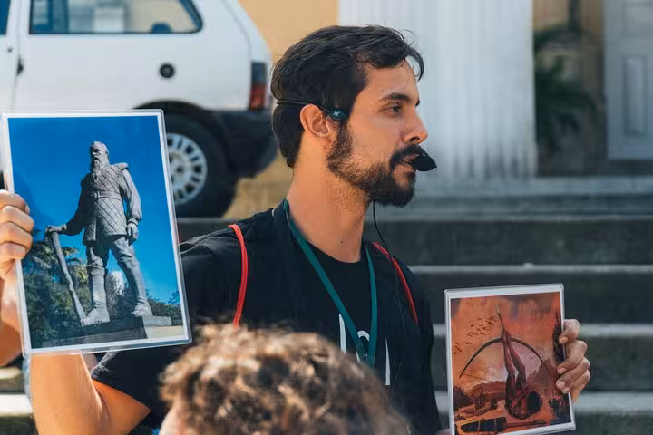 Tour guide with headset shows historical images during Florianopolis Walking Tour.