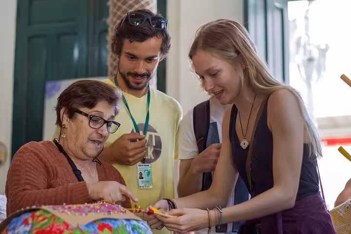 Visitors engaging with a local artisan in Florianopolis, learning traditional crafts on a cultural walking tour.