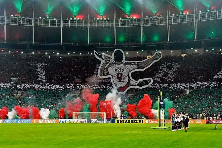 Fluminense fans light red, green and white flares at Maracanã Stadium during Rio de Janeiro matchday tour