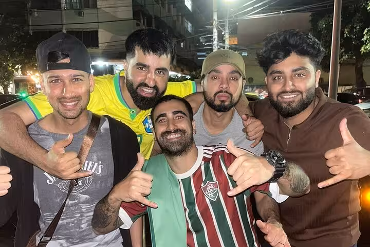 Friends wearing Fluminense jersey and Brazil shirt celebrating near Maracanã on Rio de Janeiro matchday tour