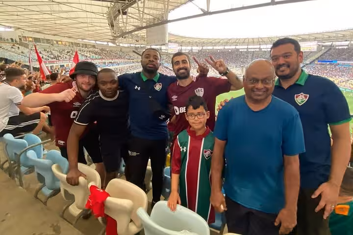 Group of Fluminense supporters posing inside Maracanã during a live Rio de Janeiro football match tour