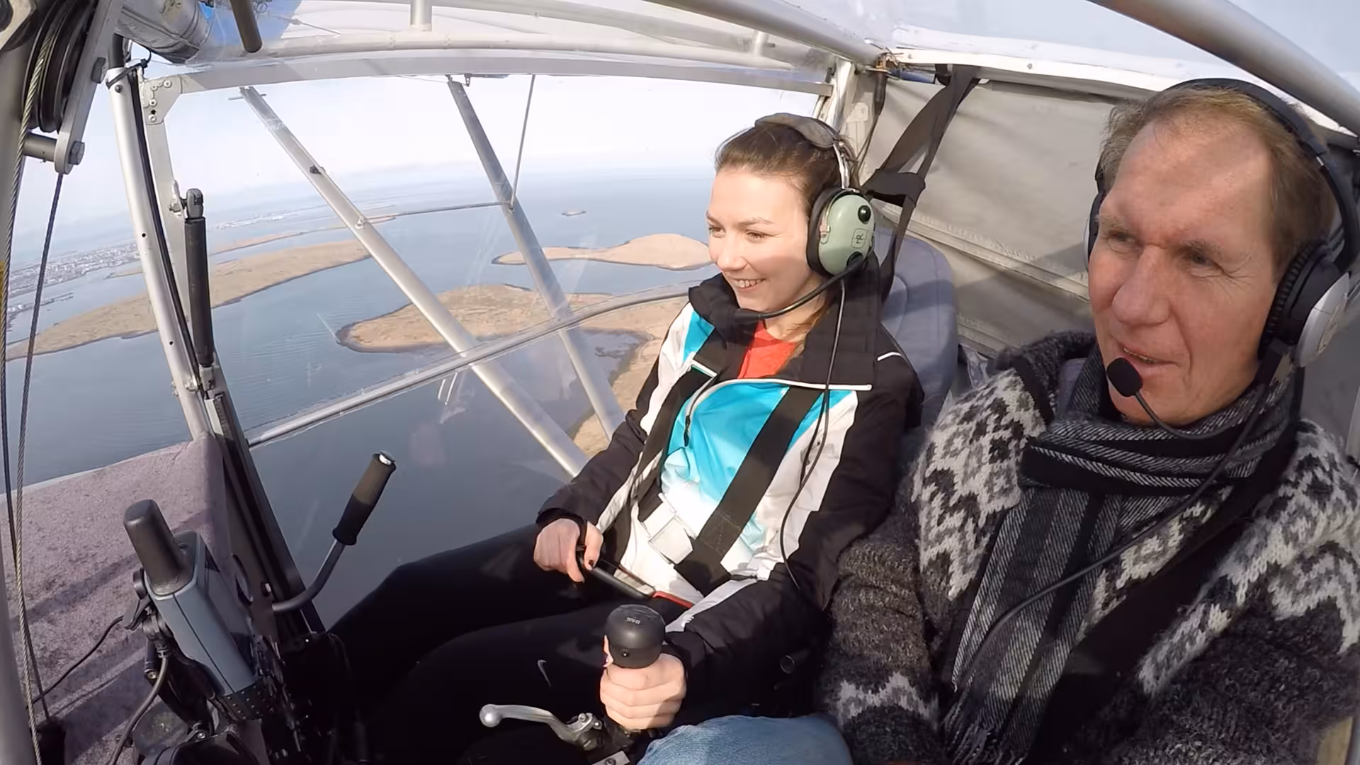Passengers wearing headsets inside a small plane during Flying Buggy sightseeing flight over islands