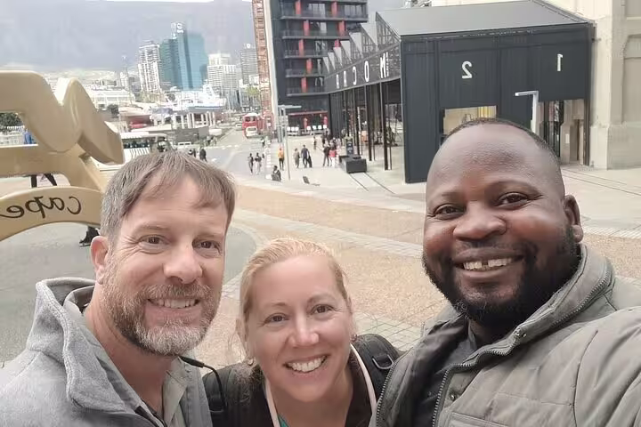 Tour participants smiling in front of a lively cityscape, capturing the essence of a food and drink adventure.