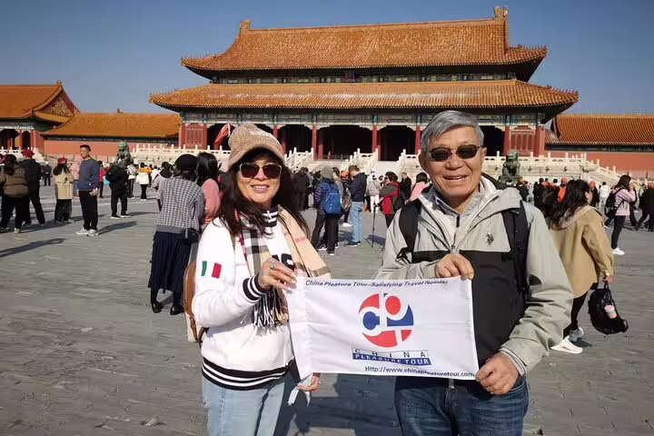 Visitors posing in front of the Forbidden City in Beijing on a 14-day private China and Yangtze River cruise tour.