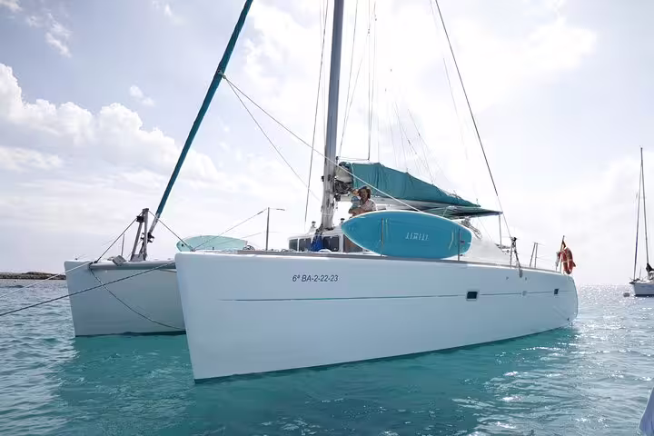 Luxurious catamaran sailing in clear turquoise waters, perfect for a Formentera and Ibiza small group adventure.
