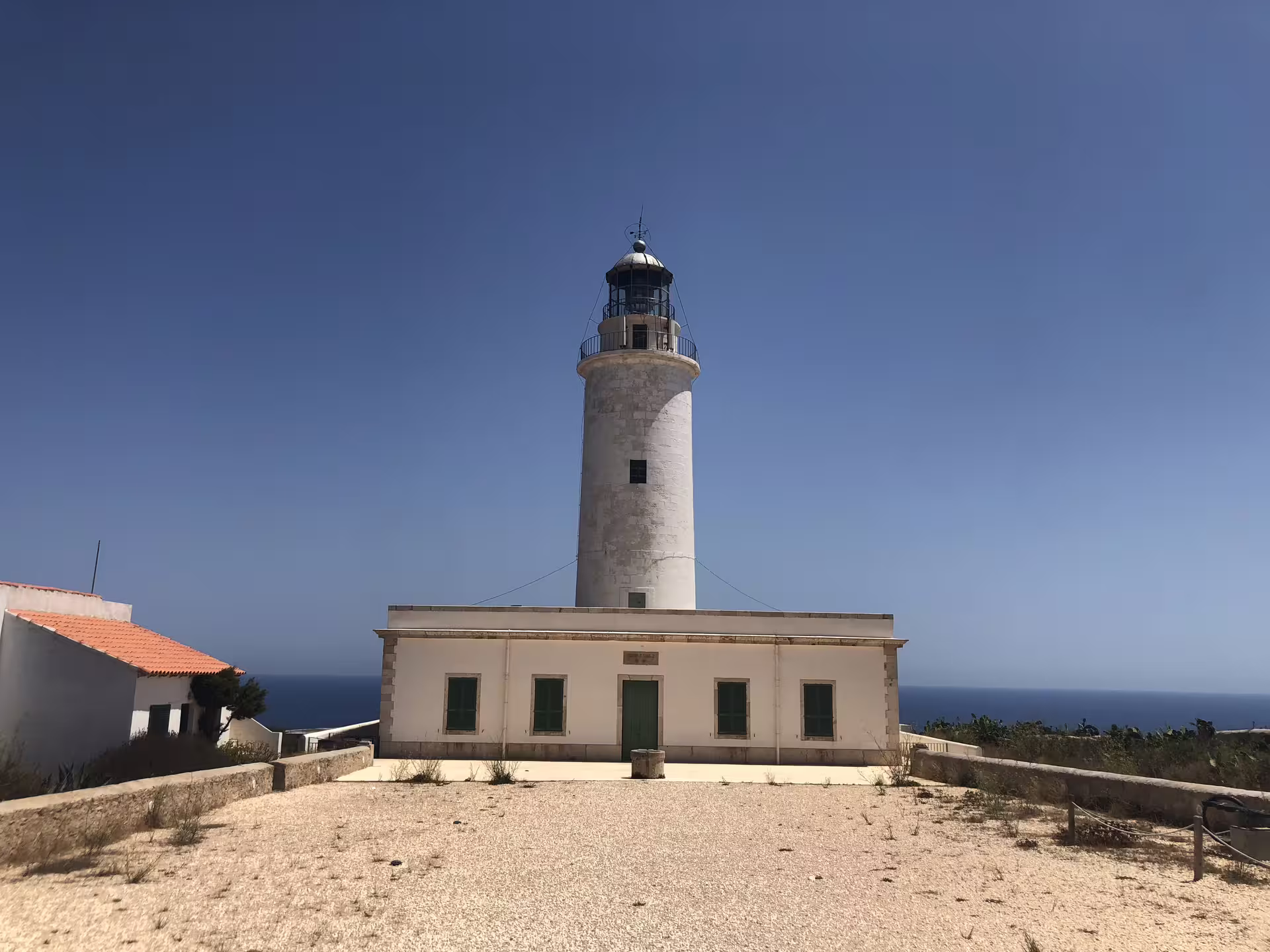Formentera lighthouse stop on Ibiza day trip with ferry and bike transfer, sea views under blue sky