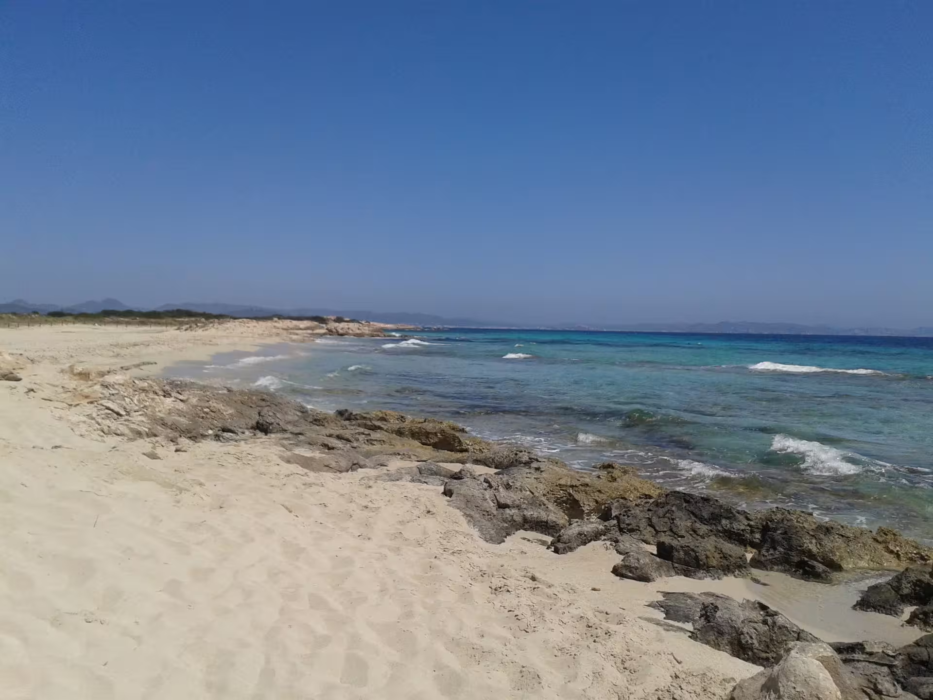Rocky Formentera coastline and crystal-clear water, beach stop on Ibiza to Formentera fast ferry excursion