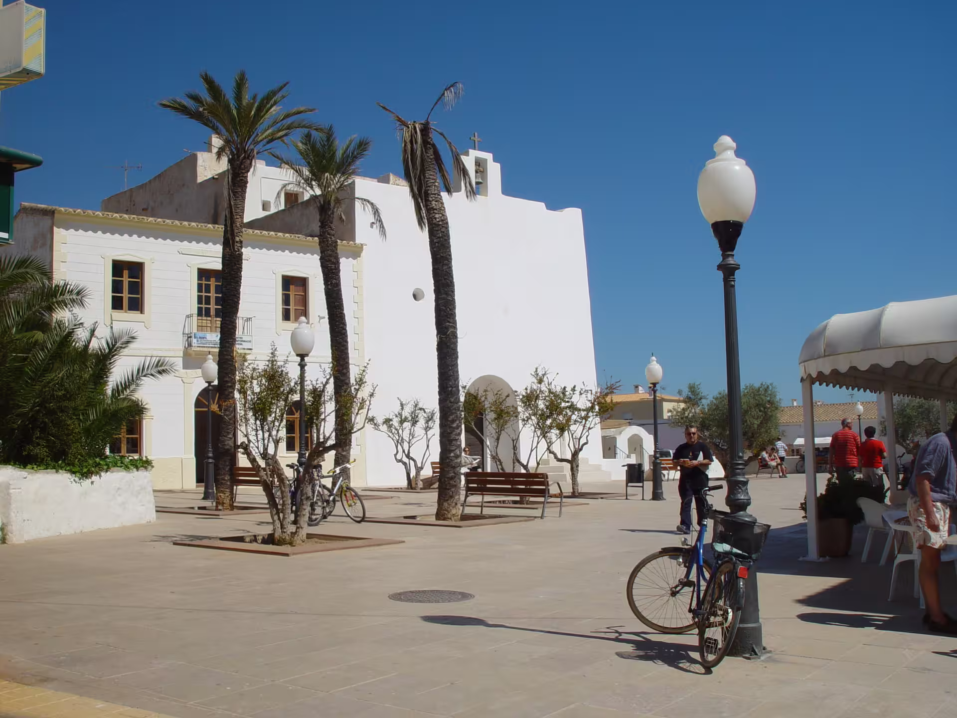 Palm-lined Formentera town square with bikes, perfect stop on Ibiza to Formentera day trip by bike and ferry