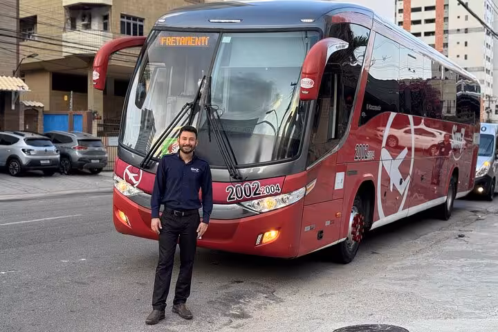 Red coach shuttle for Fortaleza Airport to Orla Marítima hotel transfer, reliable shared transportation service
