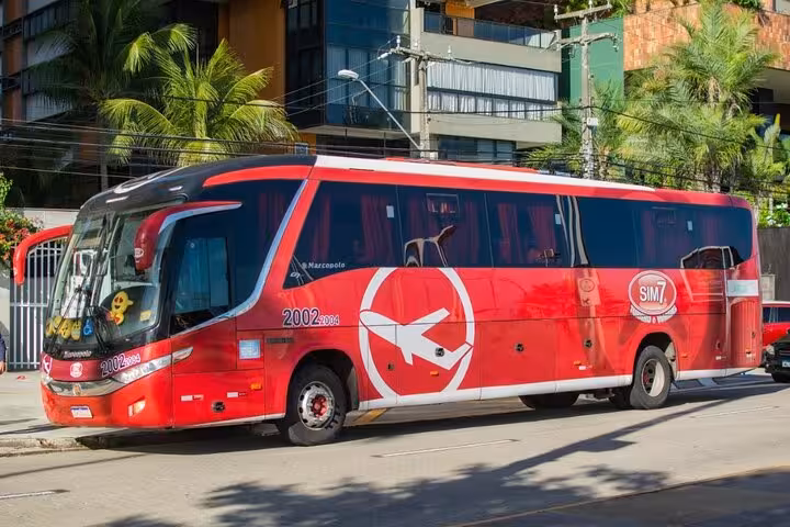 Red coach bus for Fortaleza to Jericoacoara transfer, comfortable shared shuttle service in Ceará