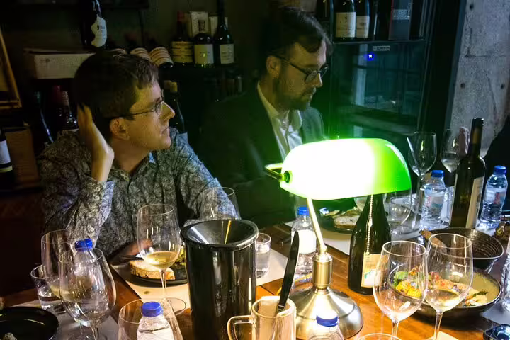 Participants enjoy a cozy fortified wine tasting session with a producer, featuring diverse wines and gourmet pairings.