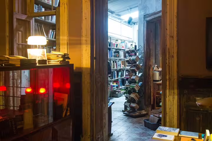 Cozy wine tasting room with warm lighting and bookshelves, perfect for a unique fortified wine experience with a producer.