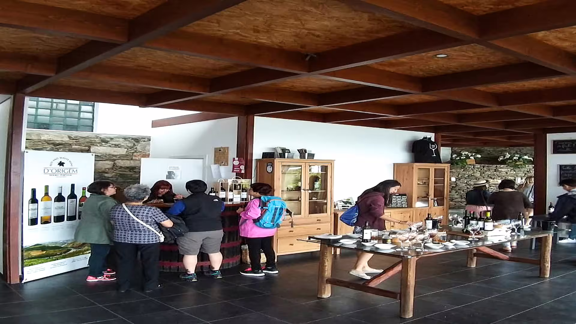 Visitors enjoying wine tasting at a rustic winery during the Foz Côa and Douro Private Tour, showcasing local wines and culture.