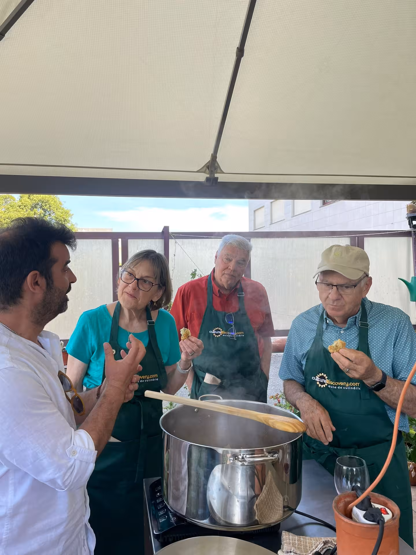 Chef instructing guests in a Porto cooking class as they taste and learn to make Francesinha.