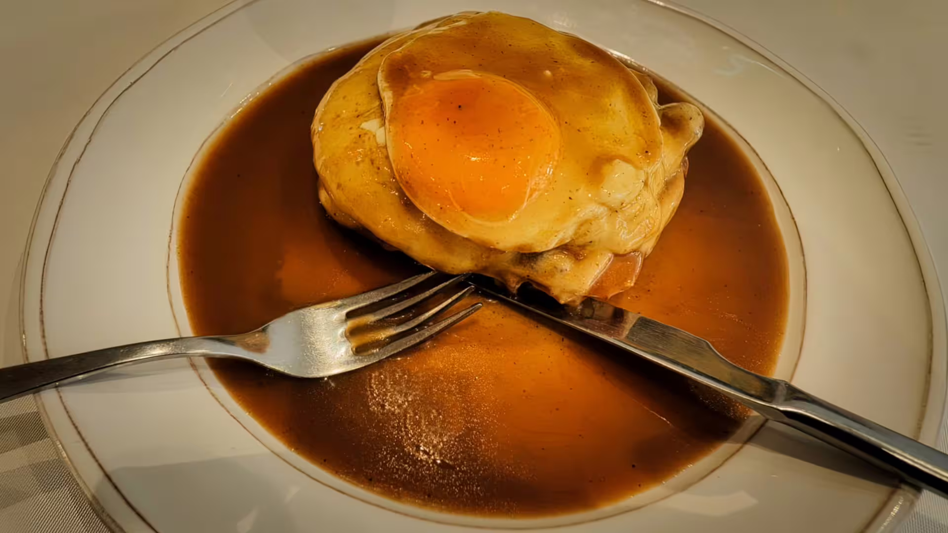 Image of a real Francesinha, like in the painting, at the original place of this iconic Porto sandwich, a stop on our Oporto Food Tour