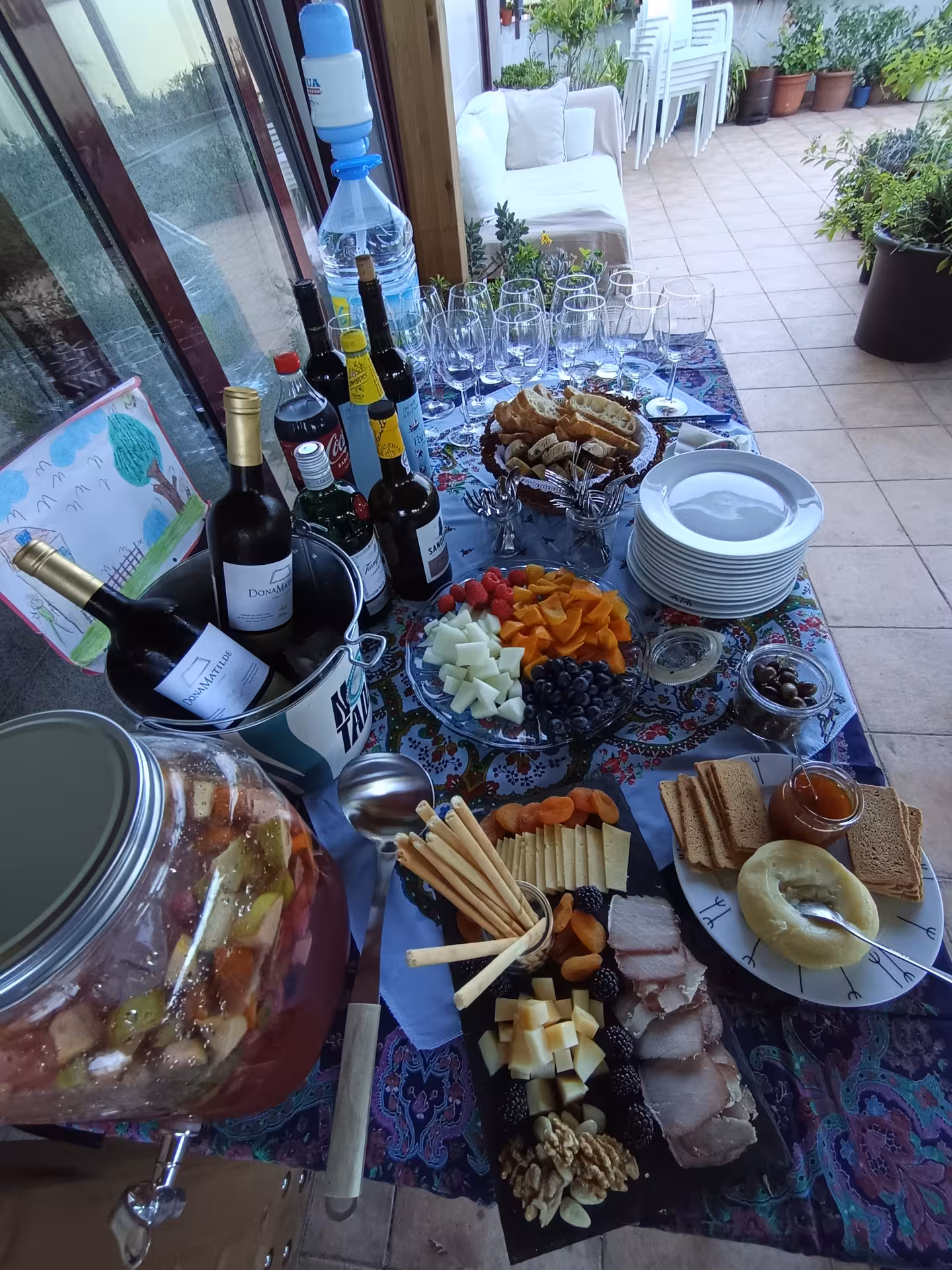 A colorful spread of wine, cheese, fruits, and charcuterie on a decorated table for a Francesinha cooking experience in Porto.