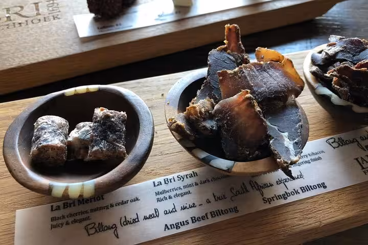 Close-up of assorted biltong and tasting notes at a Franschhoek winery, offering a true South African culinary experience.