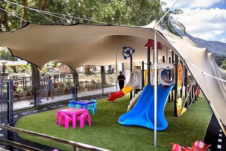 Enjoy family-friendly adventures in Franschhoek with a vibrant playground under a sunshade, perfect for children on the Blue Line tour.