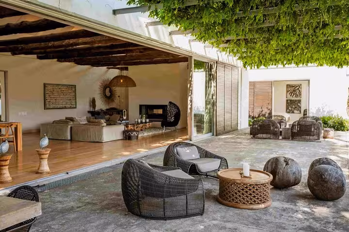 Elegant outdoor patio with wicker furniture and lush greenery, perfect for relaxation on a Franschhoek day tour.