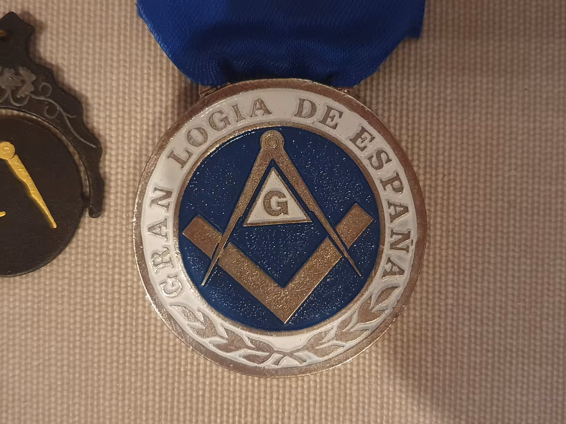 Freemason medal from Gran Logia de España with square and compass emblem, featured in La Barcelona masónica tour.