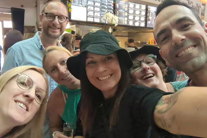 Friends taking a group selfie on a Freiburg in Breisgau scavenger hunt, exploring sights on a self-guided tour